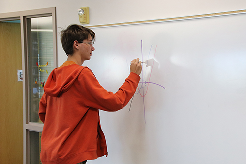 Brady Mowbray works on graph on a whiteboard